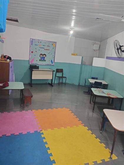 Sala com tapete de encaixe colorido, mural e mesinhas